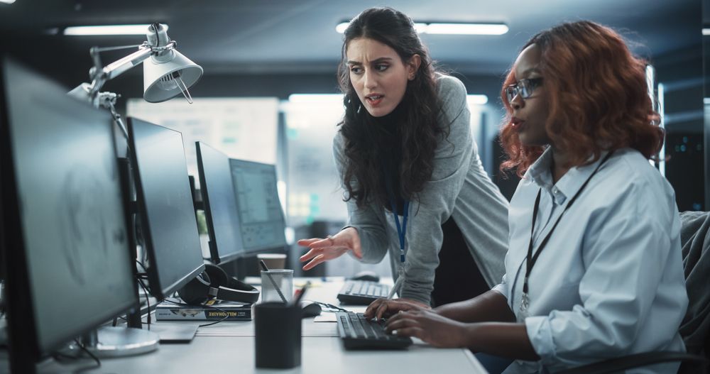 Two Diverse Colleagues Having a Conversation While Busy Working on a Team Project.