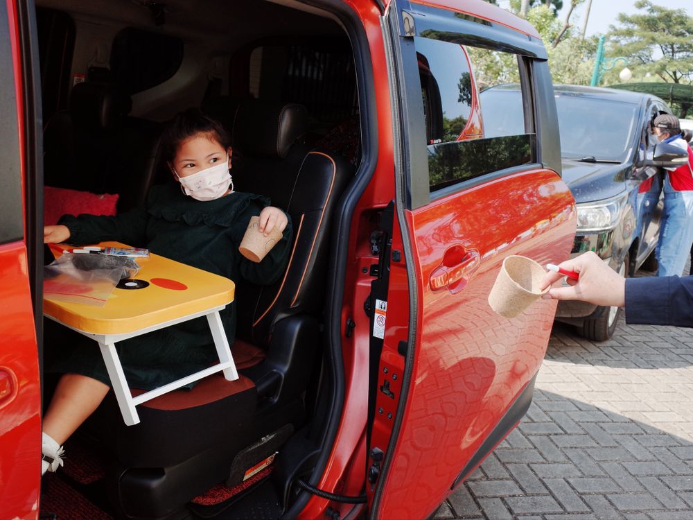 Young girl with facemask sitting in a mini bus