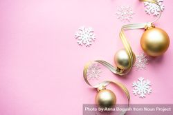Gold Christmas baubles and snowflake decorations on pink background 0yklO4
