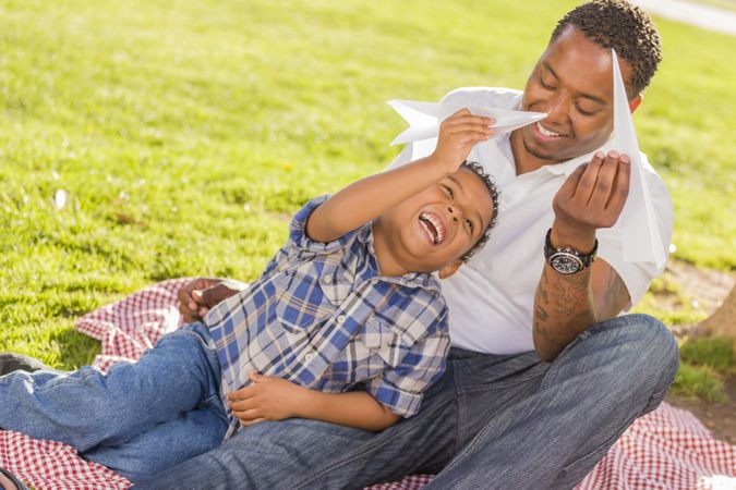 Happy Father and Son Playing with Paper Airplanes