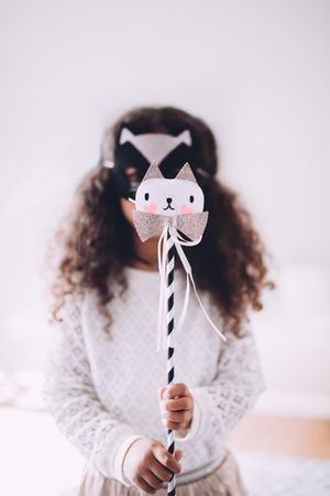 Little girl wearing an animal mask holding a wand