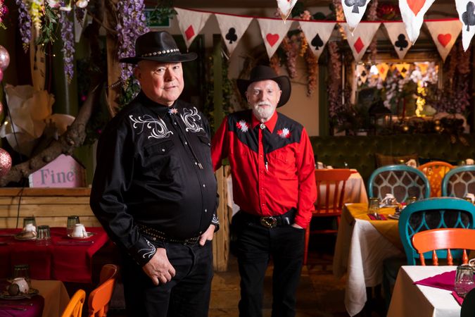 Two mature men in country western attire in line dancing bar