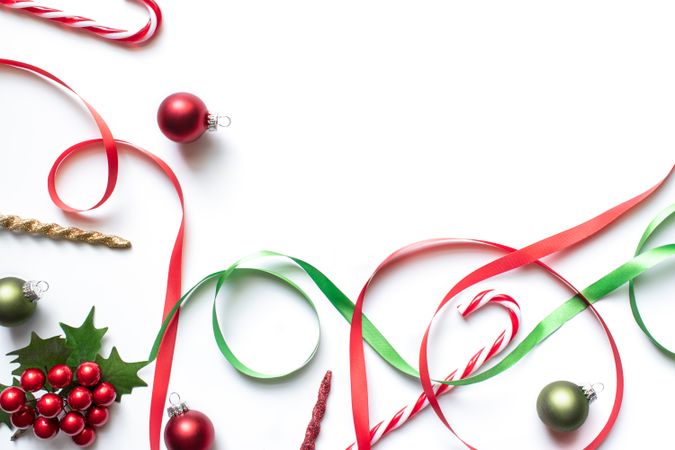 Christmas theme backdrop with red and green ornaments, ribbons, candy cane.