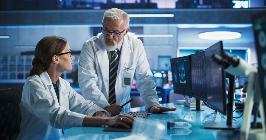 Biotechnology Research Laboratory: Two Doctors Discussing CT Brain Scan On Computer.