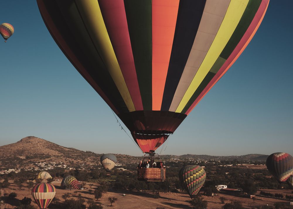 Hot air balloon with stripes in Teotihuacan Valley among group of balloons
