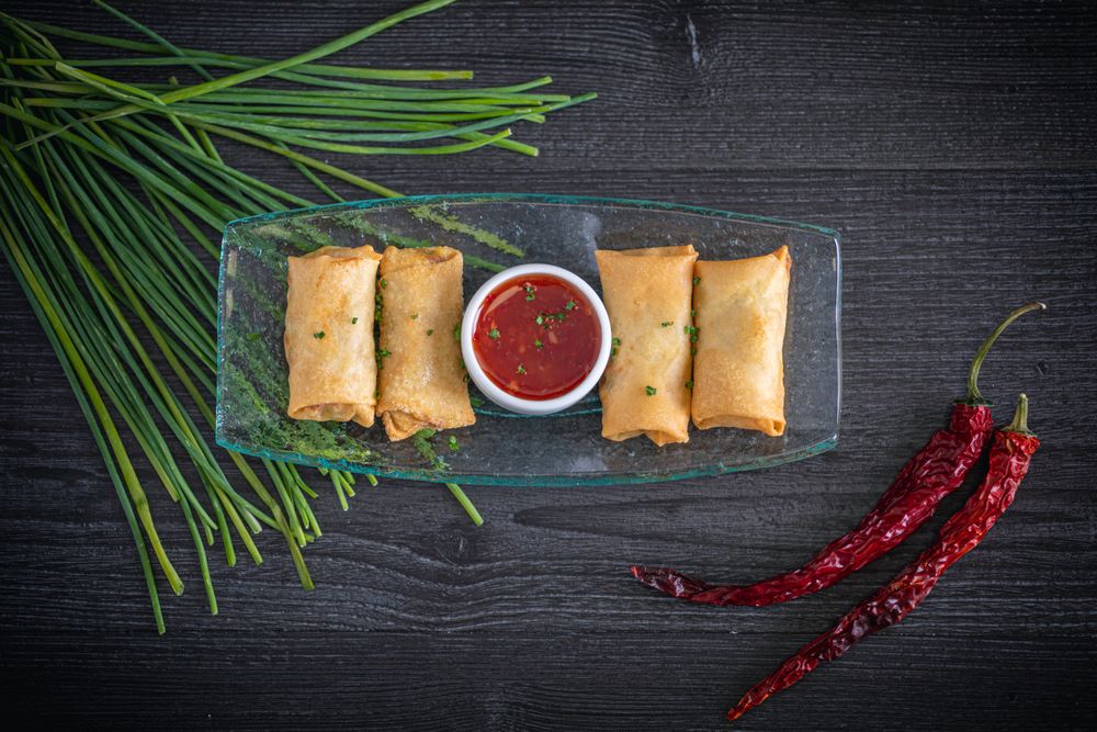 Vietnamese rolls with sweet chili on glass plate