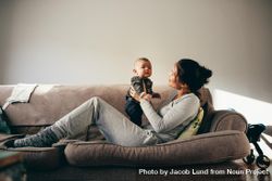 Young mother talking with her baby while relaxing on a couch 5nOOM4