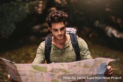Male hiker using a map to locate the destination 5aLyK0