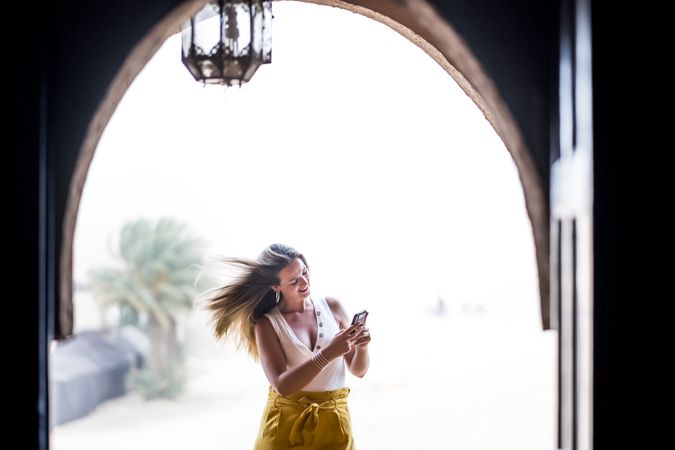 Woman using smartphone in balcony