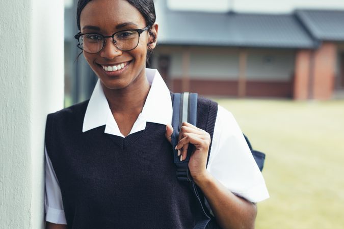 Teenage girl with schoolbag walking through the high school corridor