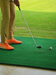 Cropped image of a person wearing yellow pants playing golf 0VyNYb