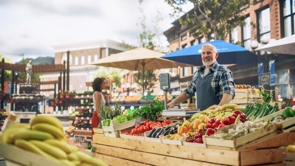 Cheerful Street Vendor Running a Small Farm Market Business, Selling Sustainable Fruits and Vegetables.