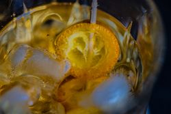 Whisky with ice and kumquat fruit