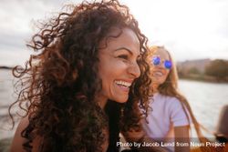 Close up shot of cheerful young woman outdoors with female friend in background 43geX4