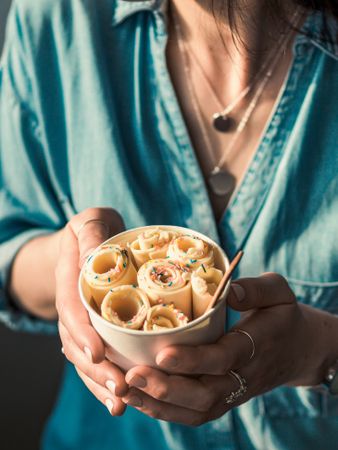 Hand holding rolled ice cream in cone cup