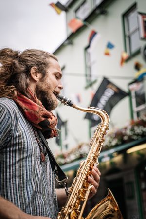 Male saxophonist plays Sax in the street