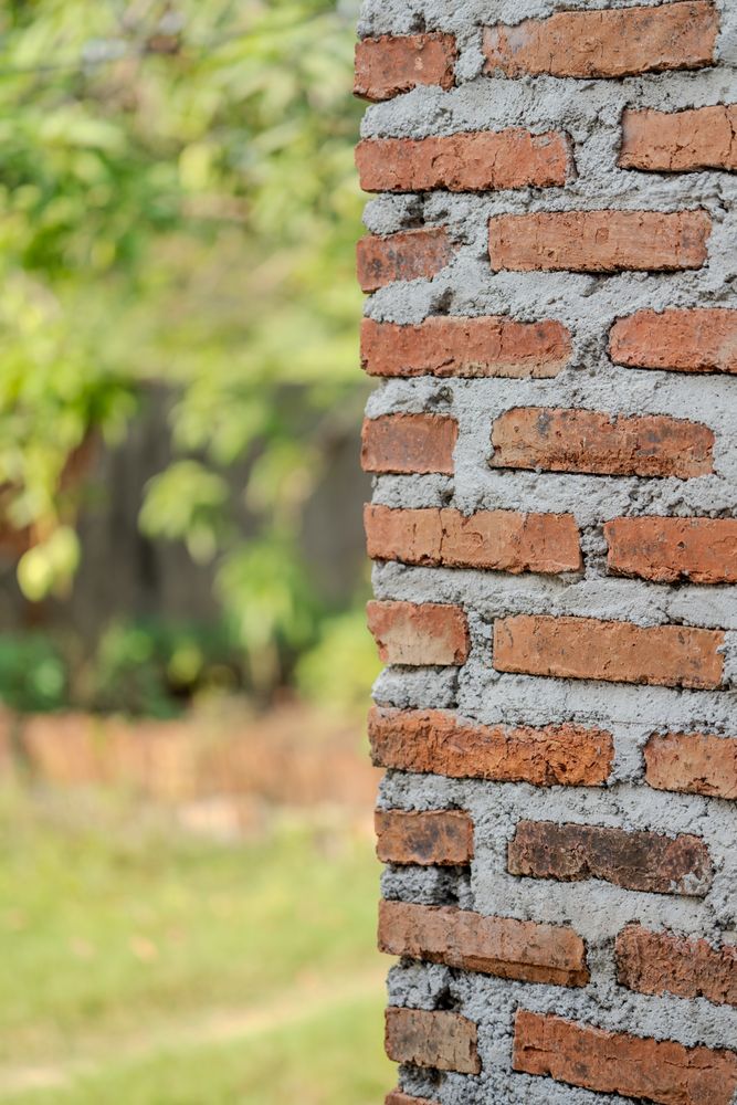 Half-collapsed brick wall with rough unfinished cement