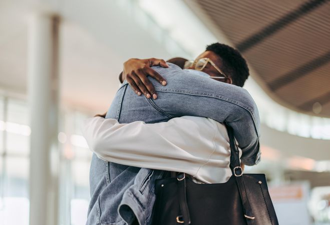 Passenger couple giving warm embrace at airport