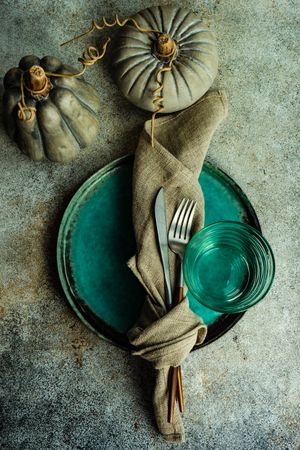 Autumnal table setting of decorative pumpkins and teal plate