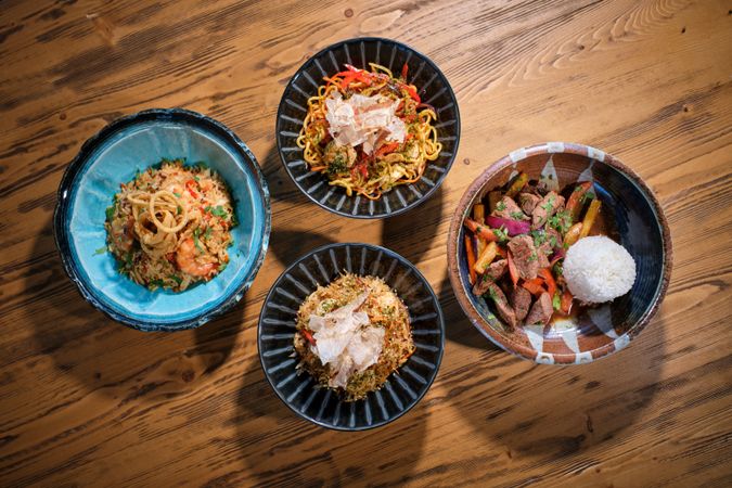 Appetizing dishes served in bowls on wooden table