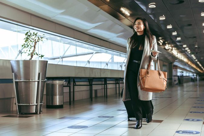 Businesswoman with luggage walking in airport terminal