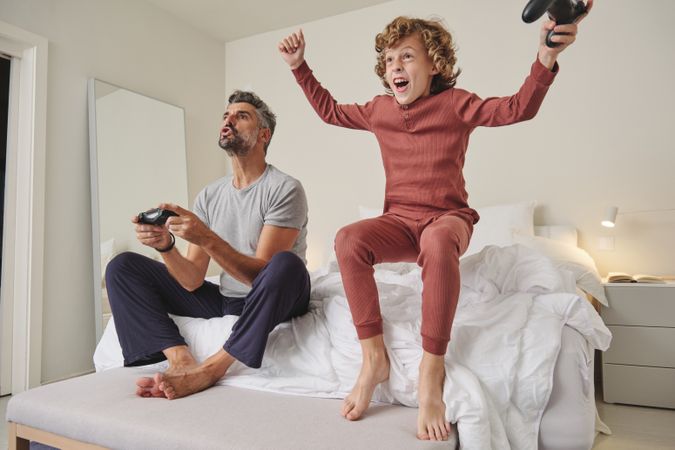 Excited kid with father playing videogame