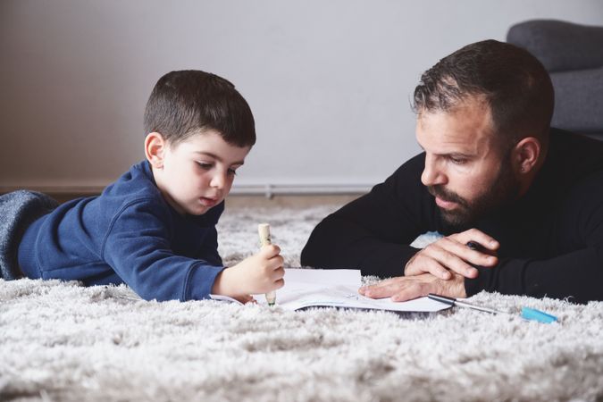 Father and son drawing on floor