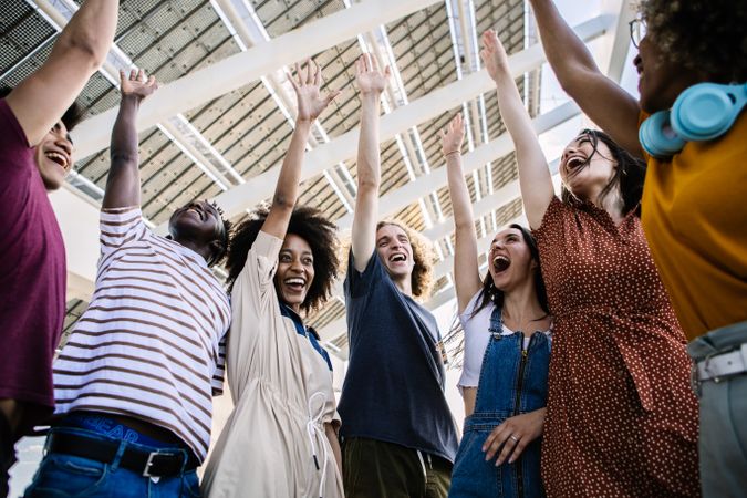 Elated friends cheering with arms up