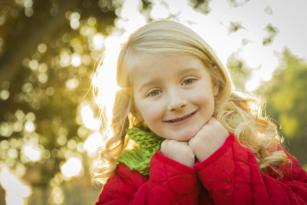 Little Girl Wearing Winter Coat and Scarf at the Park.