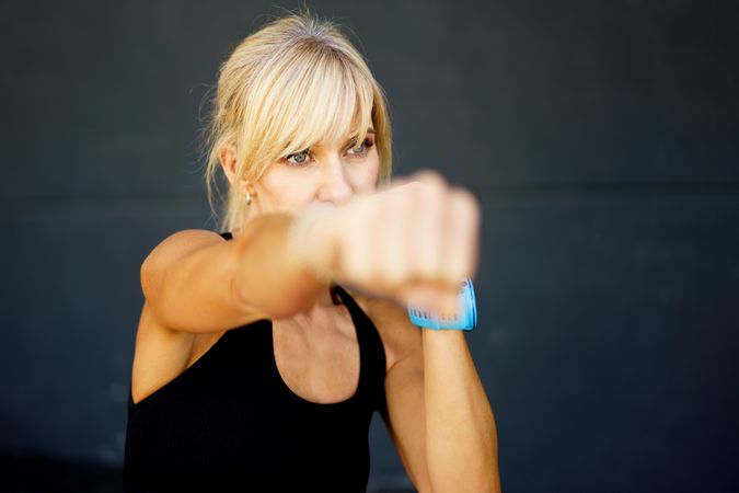 Fit blonde woman doing boxing workout in gym
