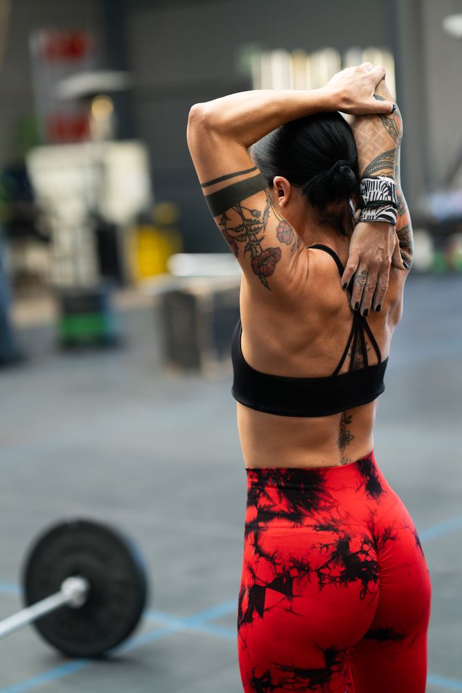 Fit woman warming up triceps with stretching