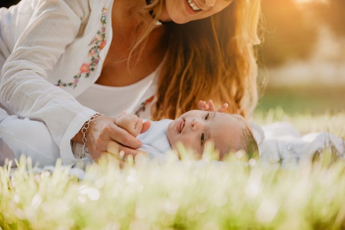 baby with down syndrome lying on a blanket with her grandmother