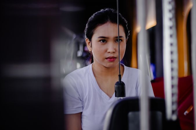 Focused young woman exercising at the gym on fitness equipment