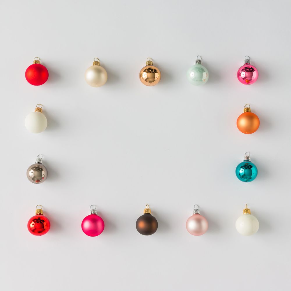 Border of colorful Christmas bauble decorations on light background