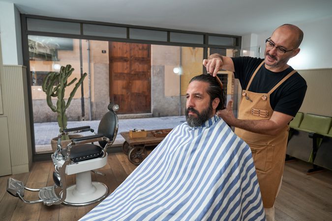 Barber combing hair of client in salon