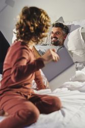 Father and son talking on bed