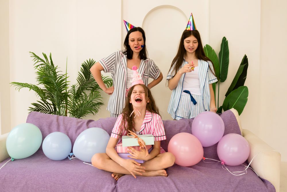 Laughing family with party accessories celebrating birthday at home.