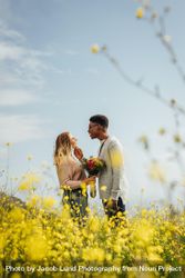 Side view of young man looking at his girlfriend holding flowers outdoors 48ogK5
