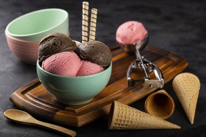 Bowl with Neapolitan ice cream on dark background.