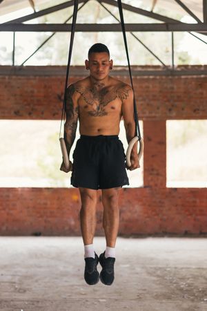 man athlete training in gymnastic rings