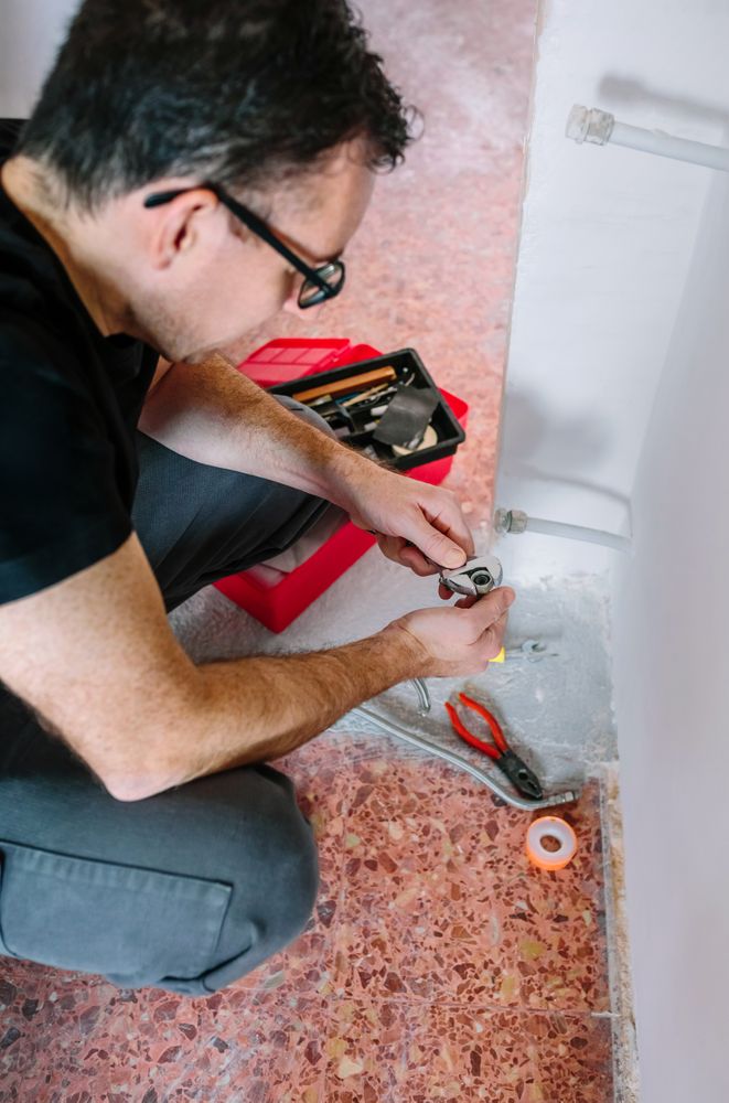 Plumber adjusting spanner to install heating