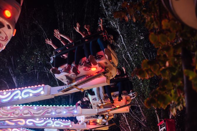 People on illuminated amusement ride in park