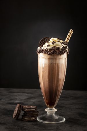 Chocolate milkshake with pieces of chocolate chip cookies.