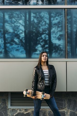 Young woman posing with skateboard