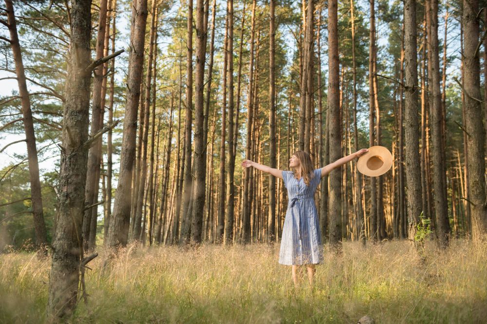 Smiling young woman relaxing among pine trees