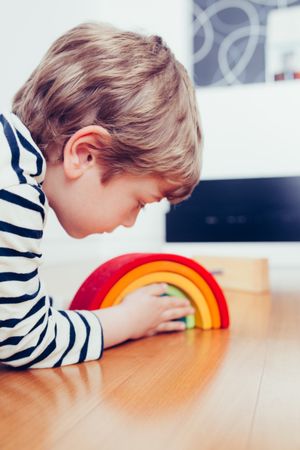 Boy playing with wooden construction pieces