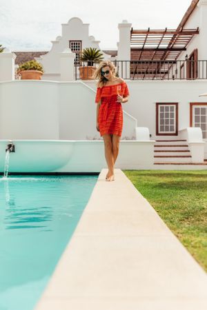 Woman walking by the pool of luxurious home