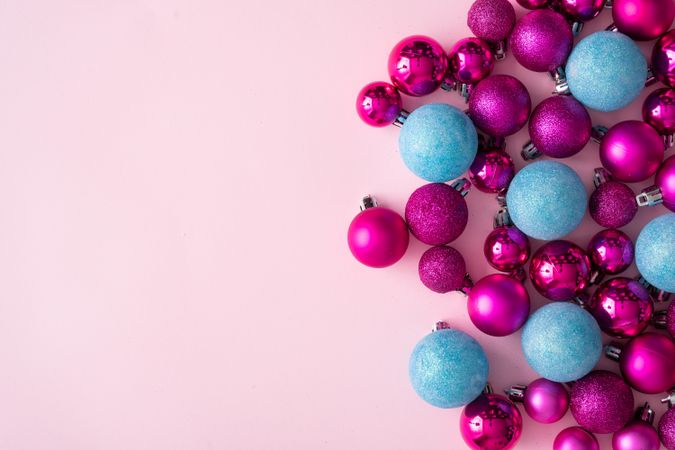Pink and blue festive baubles on side of pink background