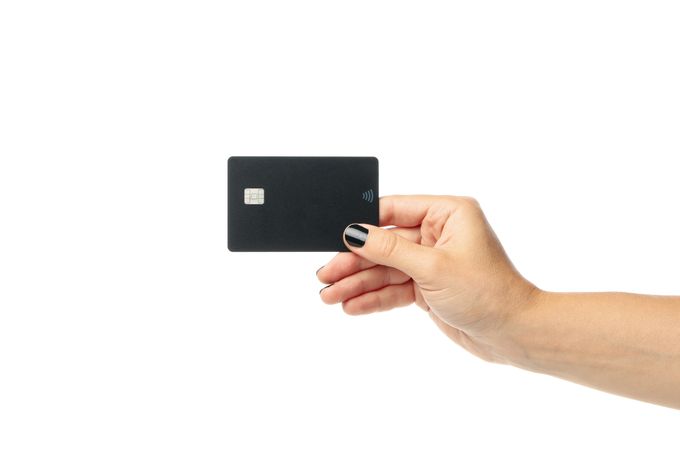 Female hand hold dark card, isolated on light background