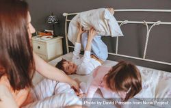 Little boy and girl playing in bed on a relaxed morning with their mother 5wZWA0